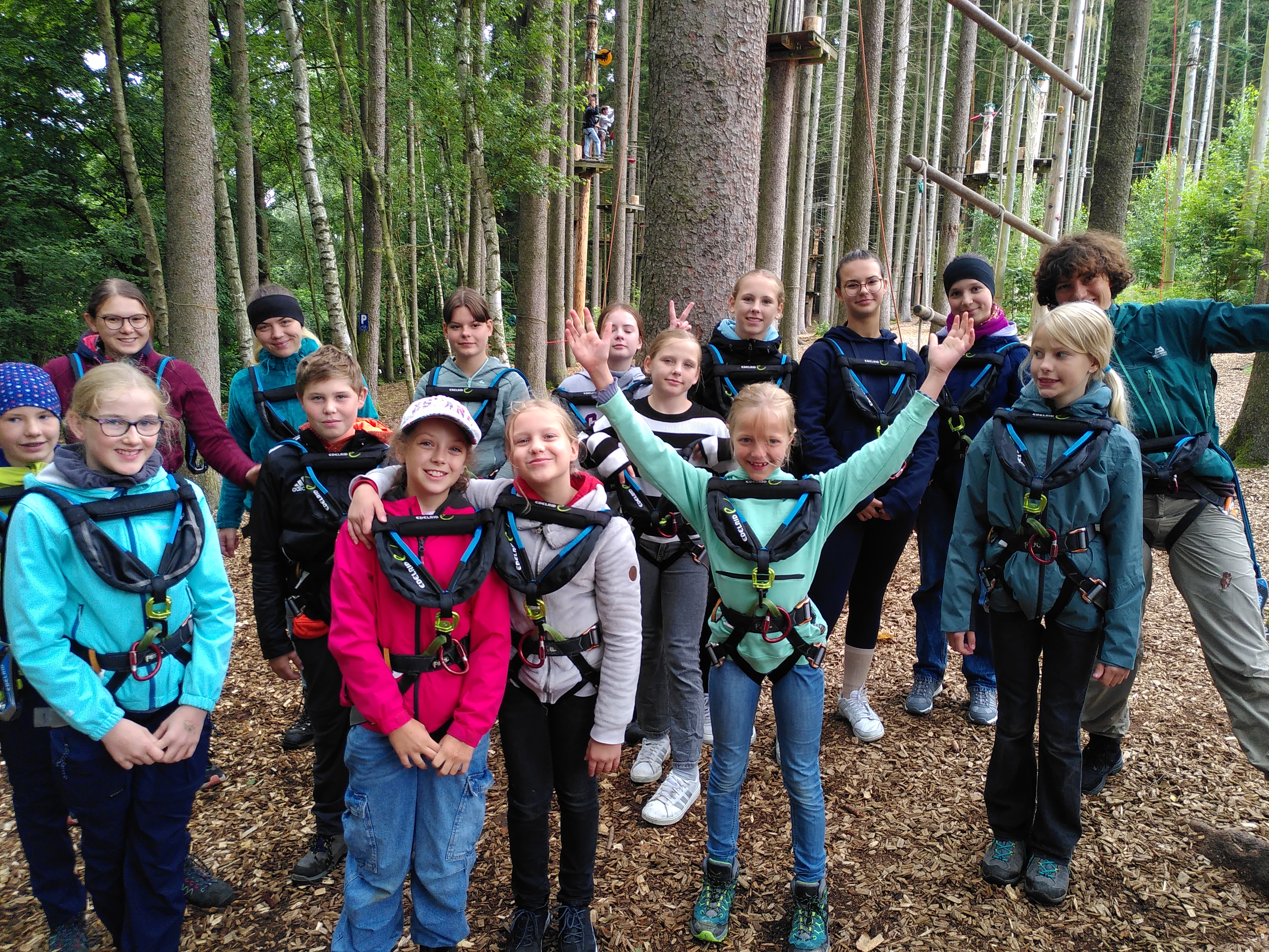 Kinder in einem Kletterwald freuen sich auf das Abenteuer.